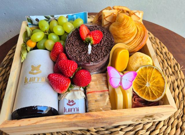 Cesta artesanal Luimi montada em caixa de madeira com frutas frescas, pães e produtos da marca