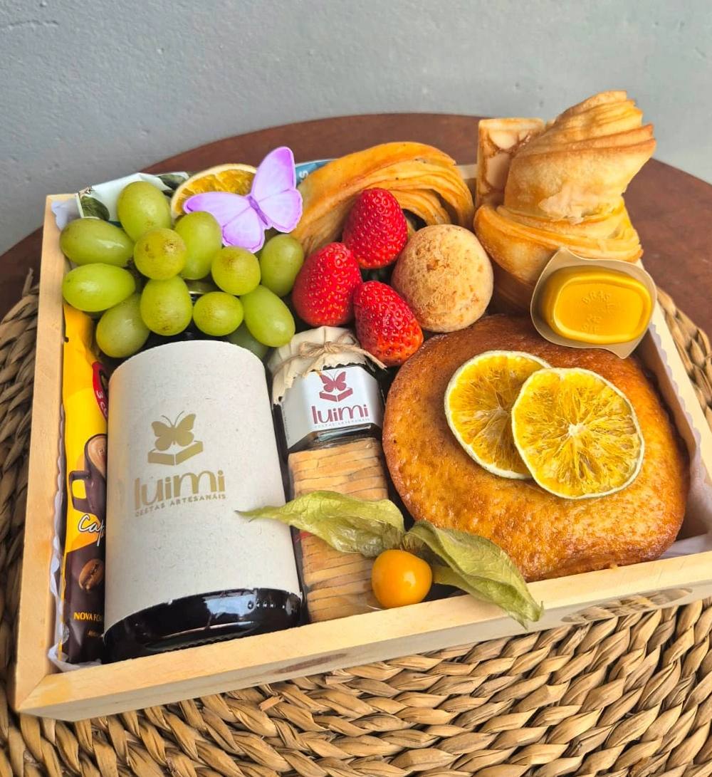 Detalhe dos itens de uma cesta de café da manhã: pães, frutas, doces e bebidas